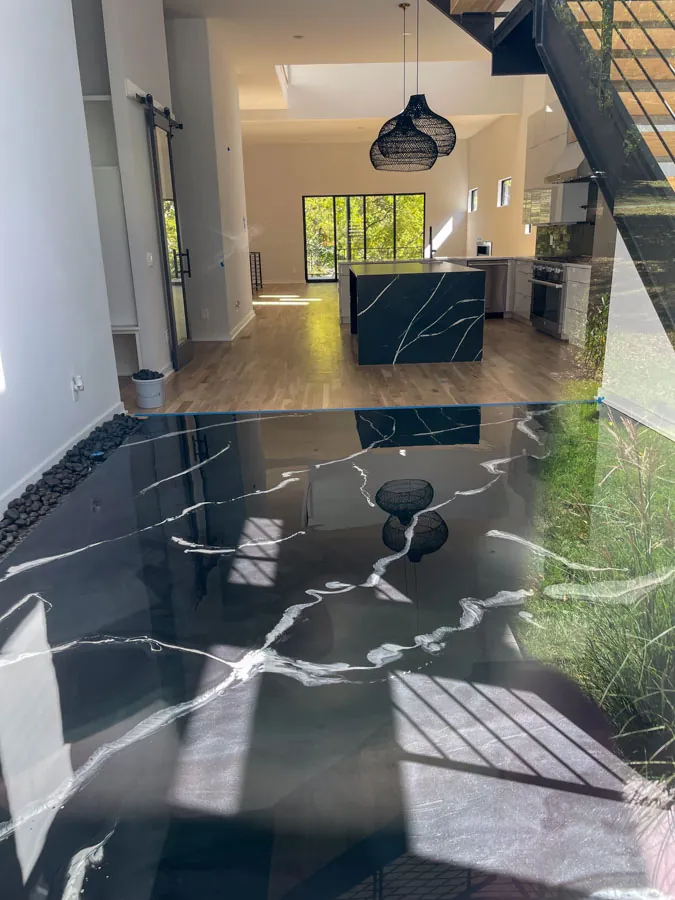 Black marble-look epoxy floor in an open-concept home, concrete coating serving Nashville, TN