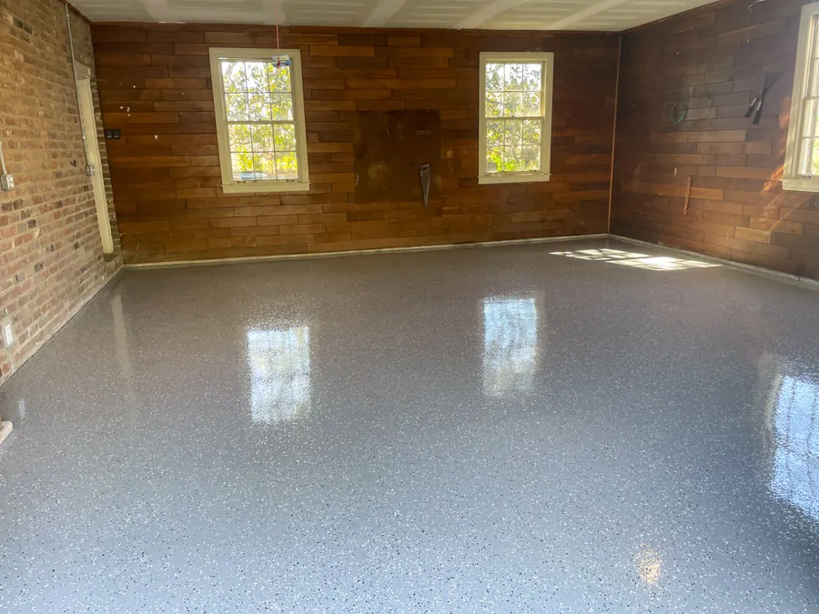 Gray flake epoxy floor in a wood-walled garage, residential epoxy flooring serving Nashville, TN
